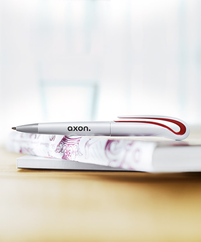 Penna promozionale argentata di design posata su di un libro.